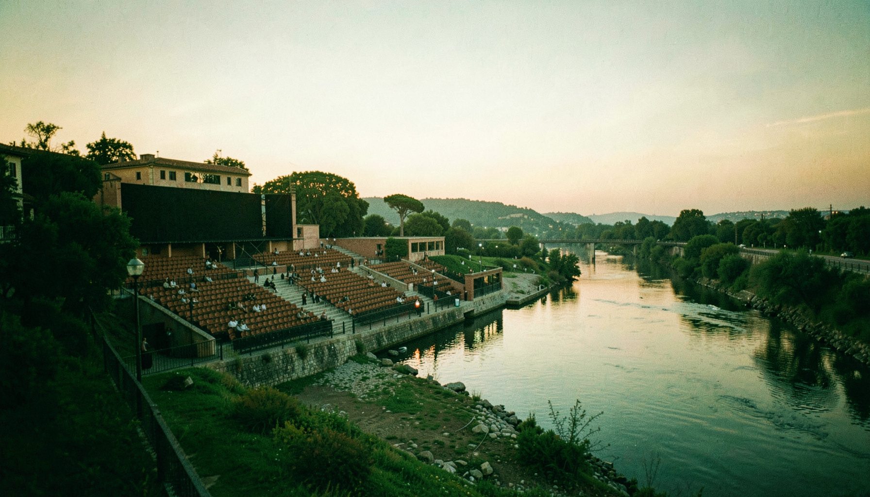 Vista amplia del auditorio CEMB junto al río Vero con tonos suaves verdes y ocres al atardecer, ambiente sereno y cinematográfico